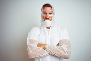 Profesyonel işçi teçhizatı takan ressam izole edilmiş arka plan şüphecisi ve gergin kolları çaprazlanmış yüz ifadesini tasvip etmiyor. Negatif kişi.