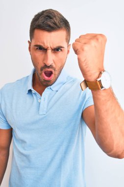 Soyutlanmış arka planda mavi tişört giyen genç ve zarif bir adam öfkeyle bağırıyor, çıldırıyor ve öfkeyle bağırıyor.