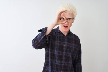 Genç albino sarışın adam, günlük gömlek ve gözlük takıyor. İzole edilmiş beyaz arka plan üzerinde. Şaşırmış yüz ifadesiyle şaşırmış, parmaklarından bakan gözler. İnançsız ifade.
