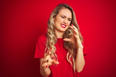 Genç, güzel bir kadın, kırmızı izole edilmiş arka planda duran, tiksindirici ve tiksindirici bir ifade takınıyor. Çünkü tiksinti tepkisi veriyor. Eller havada. Can sıkıcı bir kavram..