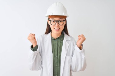 Genç Çinli mühendis kadın, gözlük takıyor. İzole edilmiş beyaz arka plan üzerinde. Şaşırmış ve şaşırmış bir şekilde kollarını kaldırıp, gözlerini açarak başarıyı kutluyor. Kazanan konsept.