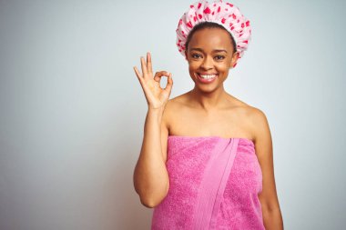 Afro-Amerikalı kadın, izole edilmiş arka plan üzerinde pembe duş havlusu ve el ve parmaklarıyla 
