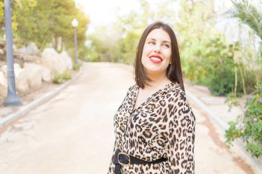 Bahçede mutlu gülümseyen kırmızı dudaklı genç güzel kadın