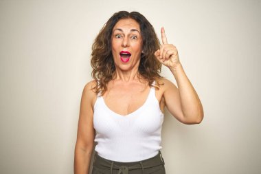 Orta yaş yaşlı kadın başarılı bir fikir ile parmak işaret beyaz izole arka plan üzerinde duran. Çıktı ve mutlu. Bir numara.