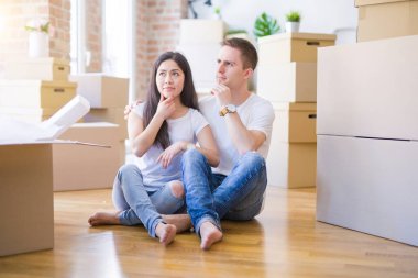 Genç ve güzel bir çift, yeni evlerinde karton kutuların etrafında oturmuş soru sormayı ciddi ciddi düşünüyorlar, çok karışık bir fikir.