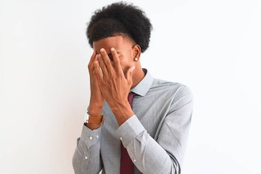 Genç Afrikalı Amerikalı iş adamı, izole edilmiş beyaz arka planda duran kravat takıyor ve ağlarken suratını ellerle kapatıyor. Depresyon kavramı.