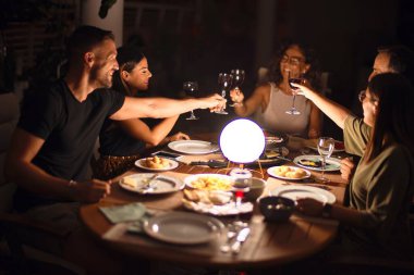 Güzel bir aile terasta bir bardak şarapla kadeh kaldırıyor.