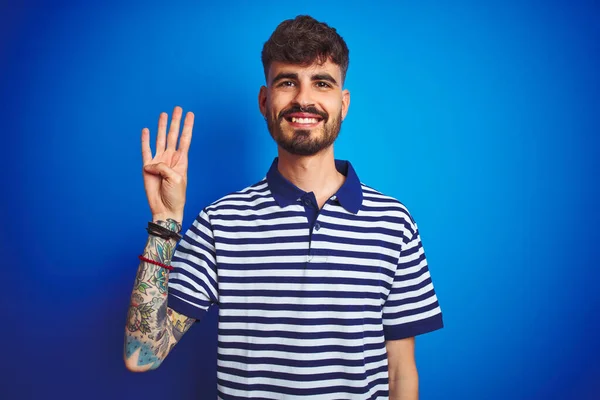 Young Man Tattoo Wearing Striped Polo Standing Isolated Blue Background — ストック写真