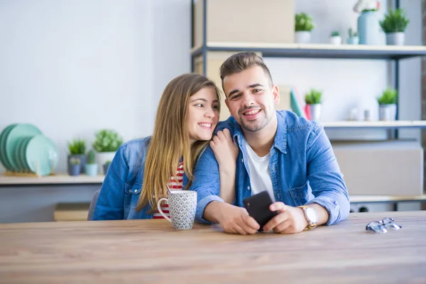 Ungt par avkopplande dricka en kopp kaffe och använda Smartph — Stockfoto