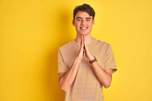 Tiener Jongen Dragen Geel Shirt Geïsoleerde Achtergrond Bidden Met Handen — Stockfoto