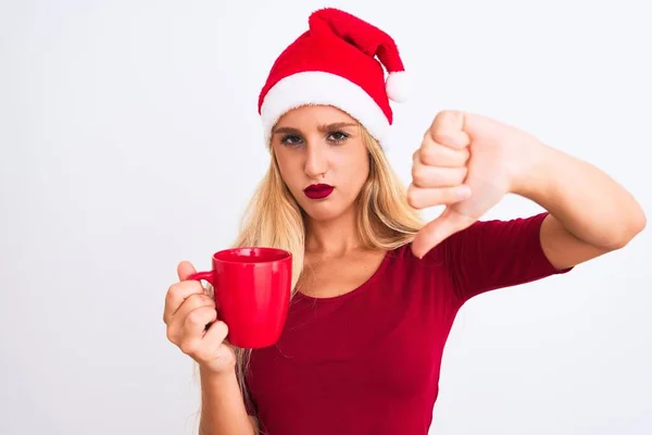 美しい女性を身に着けていますクリスマスサンタ帽子コーヒーを飲みます隔離された白い背景に怒りの顔 親指で嫌いを示す負の記号ダウン 拒絶概念 — ストック写真