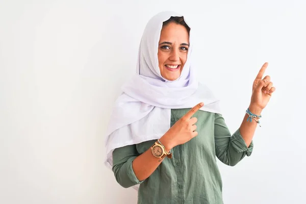 若いです美しいですアラブ女性身に着けています伝統的なイスラム教徒のヒジャーブ上の隔離された背景笑顔とカメラを見て2本の手と指で側面 — ストック写真