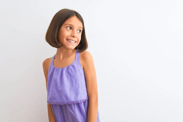 若い美しい子供の女の子の顔に笑顔で横に離れて見て孤立した白い背景の上に立って紫色のカジュアルなドレスを着て 自然な表現 自信を持って — ストック写真