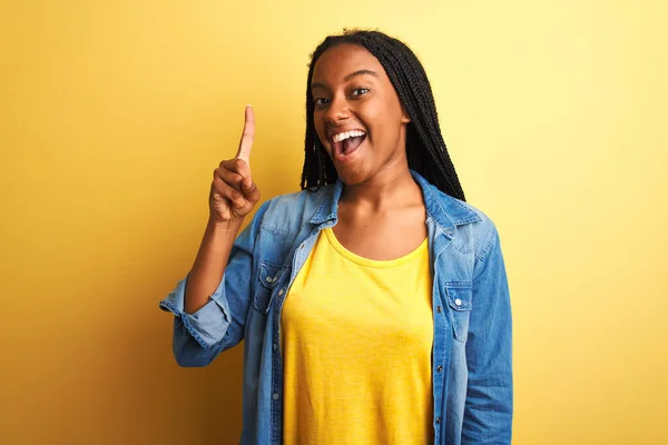 Молодая Африканская Американка Джинсовой Рубашке Стоящая Изолированном Жёлтом Фоне Показывая — стоковое фото