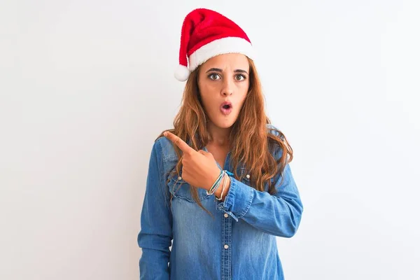 Jonge Mooie Roodharige Vrouw Draagt Kerst Hoed Geïsoleerde Achtergrond Verrast — Stockfoto
