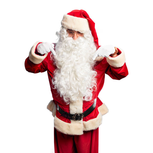 Middle age handsome man wearing Santa Claus costume and beard standing Pointing down with fingers showing advertisement, surprised face and open mouth