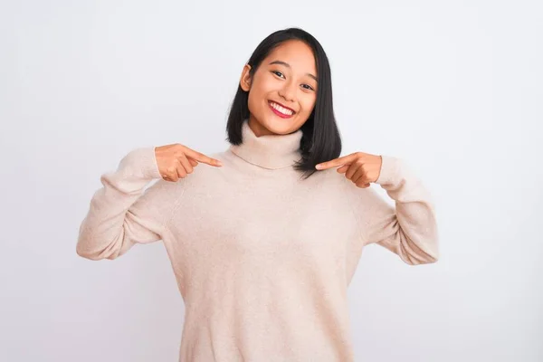 若いです中国人女性身に着けていますTurtleeckセーター立って上の孤立した白い背景を見て自信を持って笑顔で顔 指で自分自身を指して誇りに思って幸せな — ストック写真