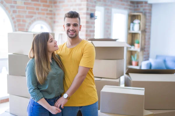 Jonge mooie paar verliefd rond kartonnen dozen verhuizen naar — Stockfoto
