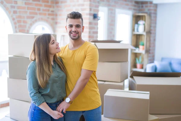 Junges schönes verliebtes Paar um Pappkartons zieht um — Stockfoto