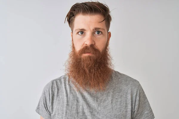 年轻红头发的爱尔兰男人穿着T恤 站在孤立的灰色背景上 脸上带着自信的表情 严肃地思考着 — 图库照片