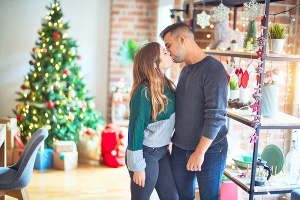 年轻漂亮的夫妇面带微笑 既快乐又自信 在家里的圣诞树旁亲吻和拥抱 — 图库照片