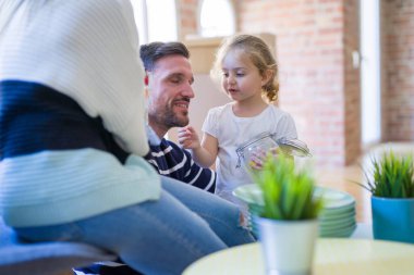 Güzel bir aile, aileler ve küçük kızlar yeni evlerinde karton kutuların etrafında.