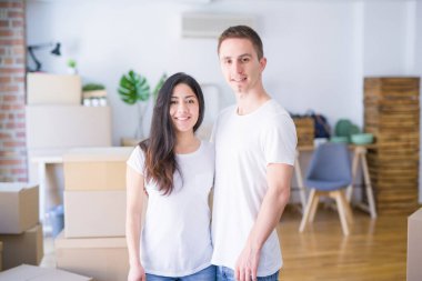 Karton kutuların etrafında duran genç ve güzel bir çift.