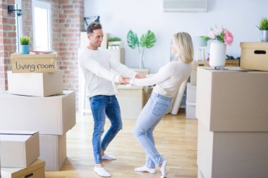 Karton kutular etrafında yeni evde dans genç güzel çift