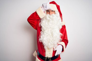 Orta yaşlı, yakışıklı, Noel Baba kostümü giymiş beyaz arka planda dikilmiş, parmakları alnında insanlarla dalga geçiyor ezik hareketler yapıyor, alay ediyor ve hakaret ediyor..