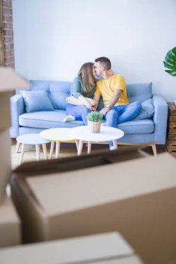 Genç güzel çift oturan ve yeni ap de kanepede sarılma