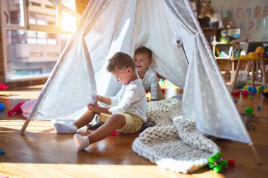 Anaokulunda bir sürü oyuncağın etrafında oynayan sevimli sarışın ikizler.