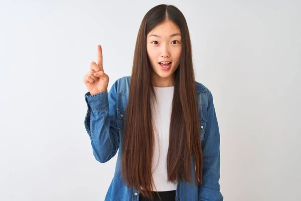 Молодая Китаянка Джинсовой Рубашке Стоящая Изолированном Белом Фоне Показывая Пальцем — стоковое фото