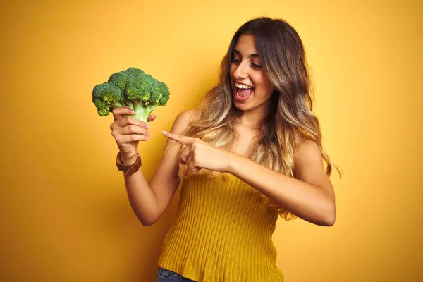 Ung Vacker Kvinna Äter Broccoli Över Gul Isolerad Bakgrund Mycket — Stockfoto
