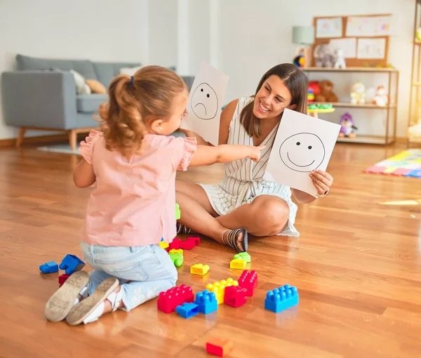 美しいです心理学者とブロンド幼児女の子座っています床の上で治療を行います絵文字の感情を使用してコンサルティングルーム — ストック写真