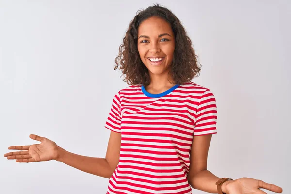 赤の縞模様のTシャツを着た若いブラジル人女性が孤立した白い背景の上に立って笑顔陽気にオープン腕で優しい歓迎 正と自信を持って挨拶 — ストック写真