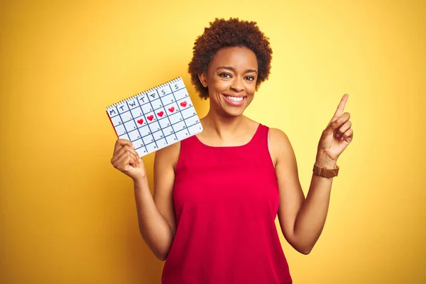 Jonge Afrikaanse Amerikaanse Vrouw Houden Menstruatie Kalender Geïsoleerde Gele Achtergrond — Stockfoto