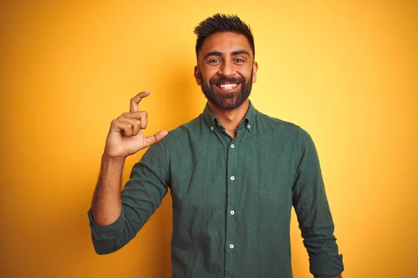 孤立した白い背景の上に立ってエレガントなシャツを着て若いインドのビジネスマンは笑顔と指を見て カメラと小さなサイズの看板を行う手で自信を持ってジェスチャー 概念の測定 — ストック写真