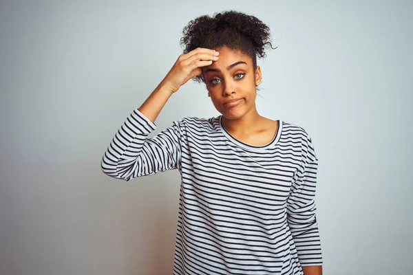 African american woman wearing navy striped t-shirt standing over isolated white background worried and stressed about a problem with hand on forehead, nervous and anxious for crisis