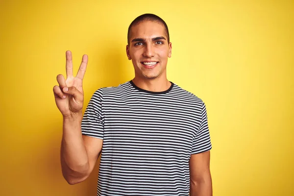 Mladý Pohledný Muž Nosí Pruhované Tričko Přes Žluté Izolované Pozadí — Stock fotografie
