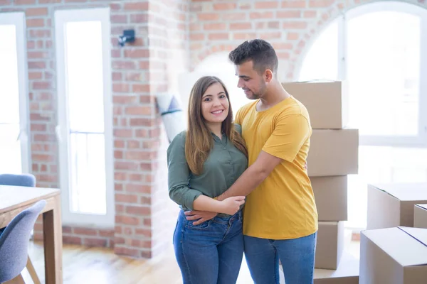 Joven hermosa pareja enamorada alrededor de cajas de cartón que se mueven a — Foto de Stock