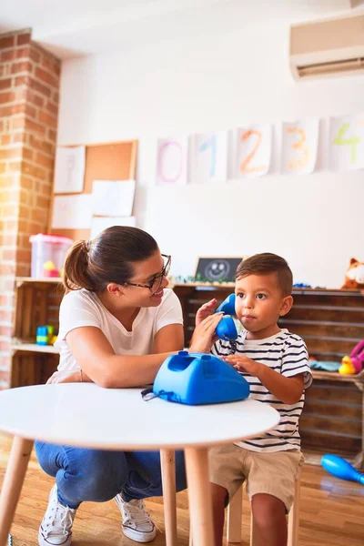 Güzel Öğretmen Küçük Çocuk Anaokulunda Klasik Mavi Telefonla Oynuyor — Stok fotoğraf
