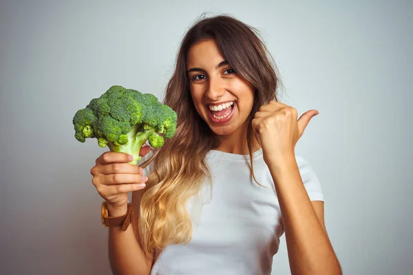 Ung Vacker Kvinna Äter Broccoli Över Grå Isolerad Bakgrund Pekar — Stockfoto