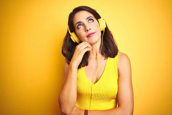 Молодая Красивая Женщина Слушает Музыку Используя Наушники Желтом Изолированном Фоне — стоковое фото