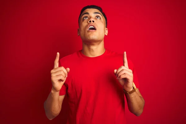 Jovem Brasileiro Vestindo Camiseta Sobre Fundo Vermelho Isolado Espantado Surpreso — Fotografia de Stock