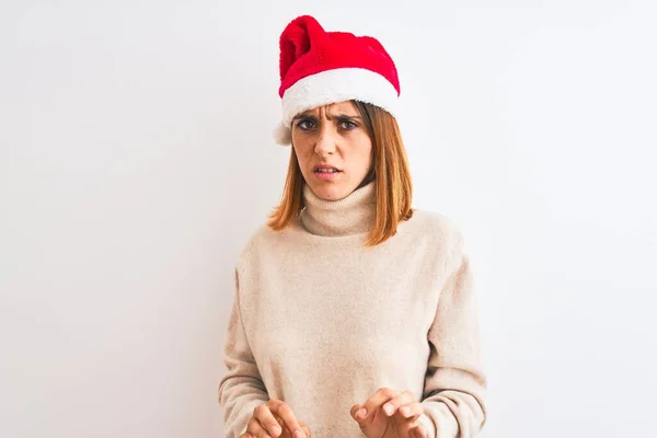 孤立した背景の上にクリスマスの帽子を身に着けている美しい赤毛の女性は嫌悪反応のために嫌悪感の表情 不満で恐ろしい嫌な顔をしている 手を上げてどんなコンセプトでも — ストック写真
