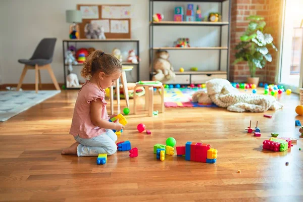 Schöne Blonde Kleinkind Mädchen Spielt Mit Plastikklötzen Einen Turm Kindergarten — Stockfoto