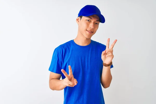 티셔츠를 모자를 중국인 맨이하얀 손가락 승리의 표시를 바라보고 — 스톡 사진