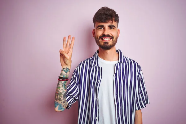 Mladý Muž Tetováním Sobě Pruhovanou Košili Stojící Nad Izolované Růžové — Stock fotografie