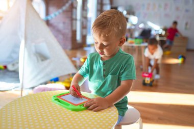 Anaokulunda bir sürü oyuncakla oynayan sevimli çocuklar.