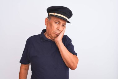 Siyah polo giyen yaşlı gri saçlı bir adam ve izole edilmiş beyaz arka plan üzerinde Kaptan şapkası. Kolları çaprazlanmış depresyondan sıkılmış ve yorgun görünüyor..